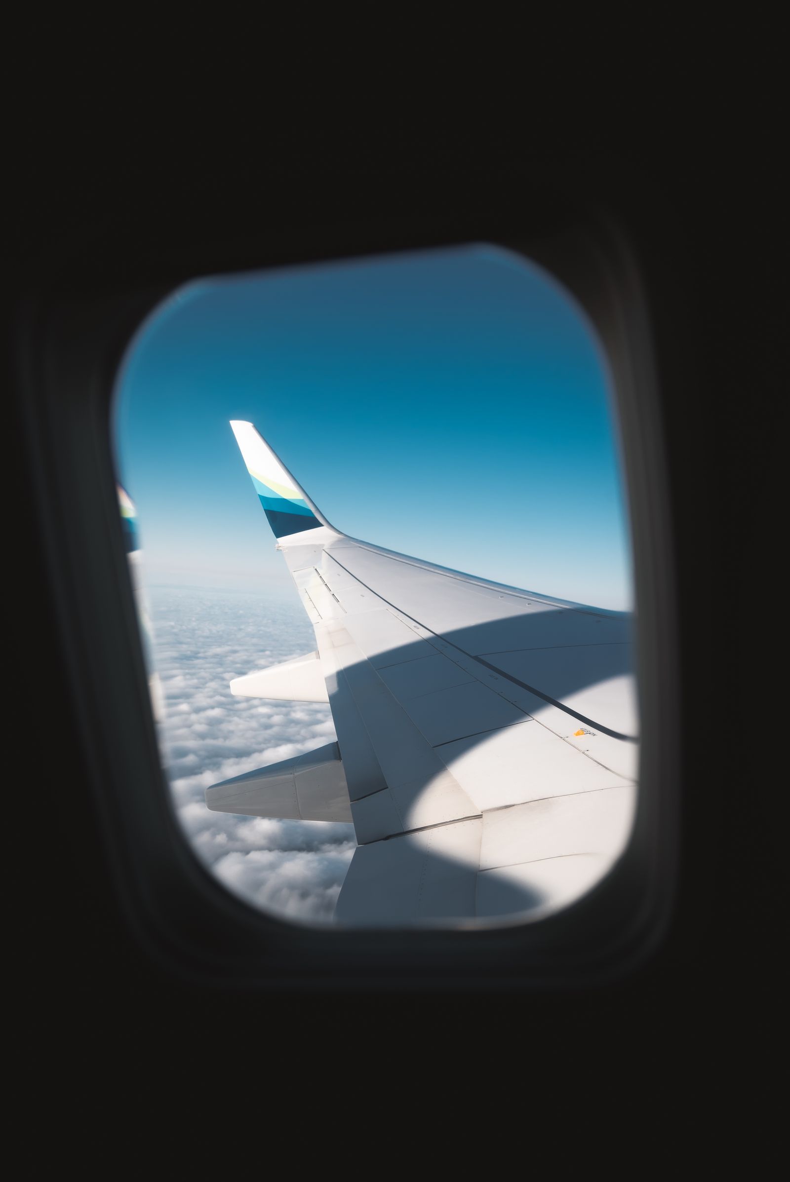 View from an airplane window over clouds, representing the journey from the USA to India