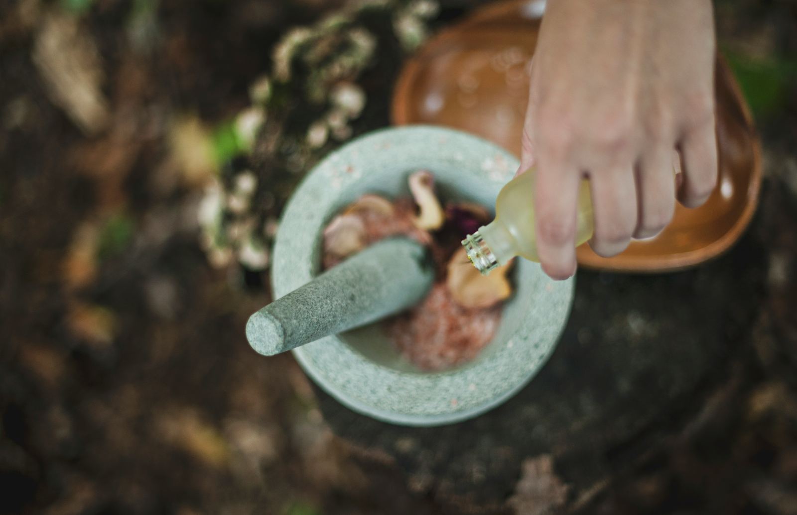 Ayurvedic herbs being prepared with a traditional mortar and pestle