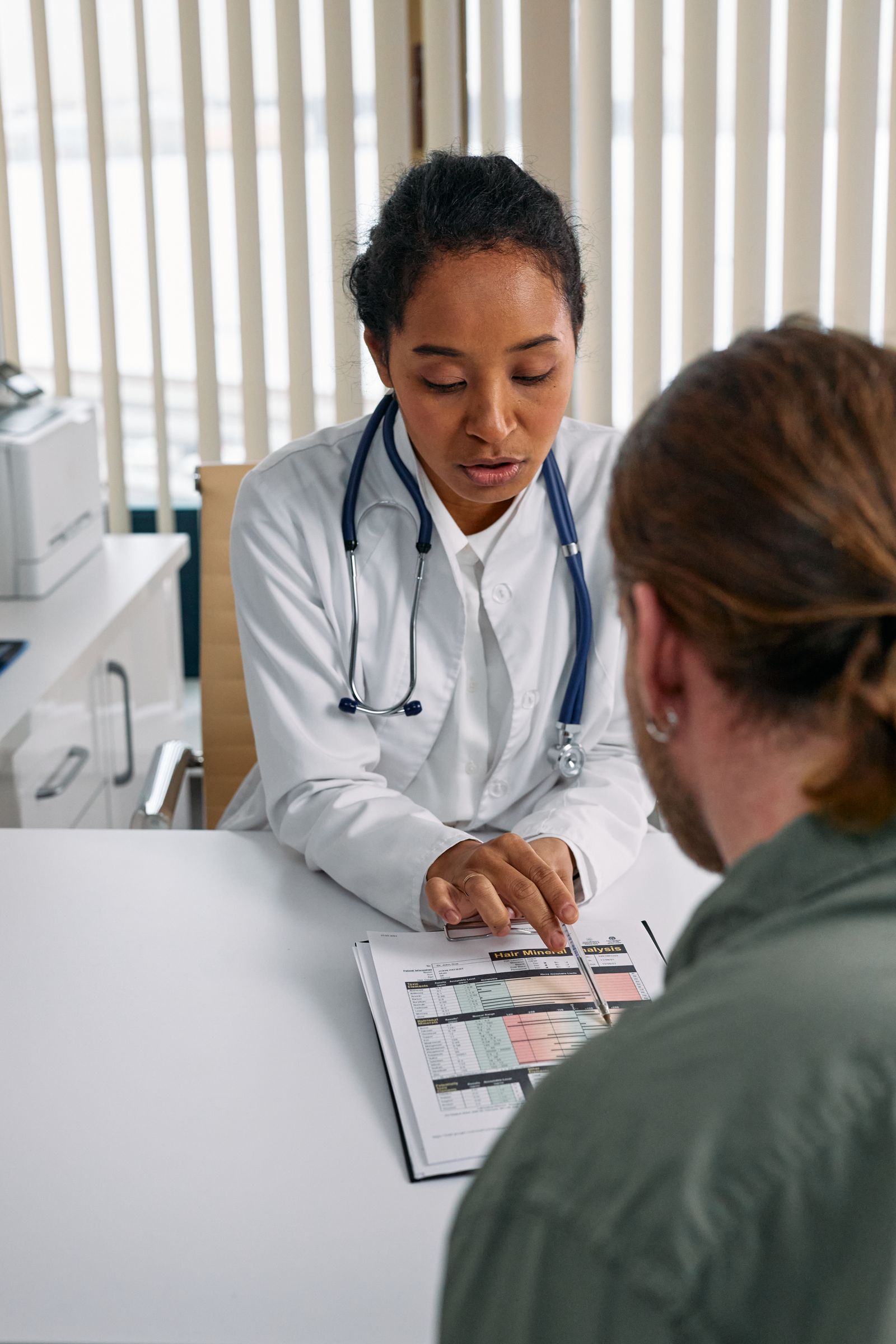 Female doctor discussing a health chart with a patient during a consultation