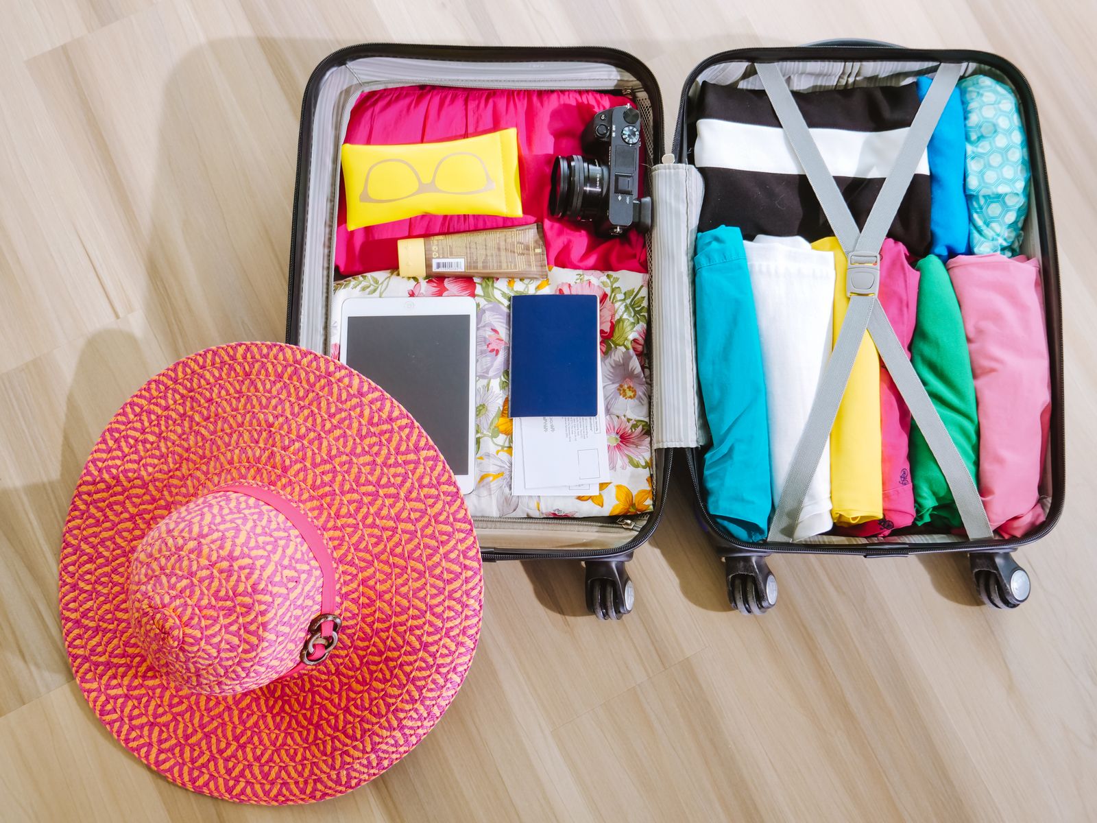 Packed suitcase with travel essentials laid out, flat lay view